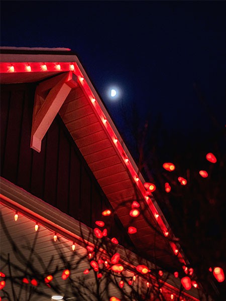Christmas lights outlining a home's roof line and windows